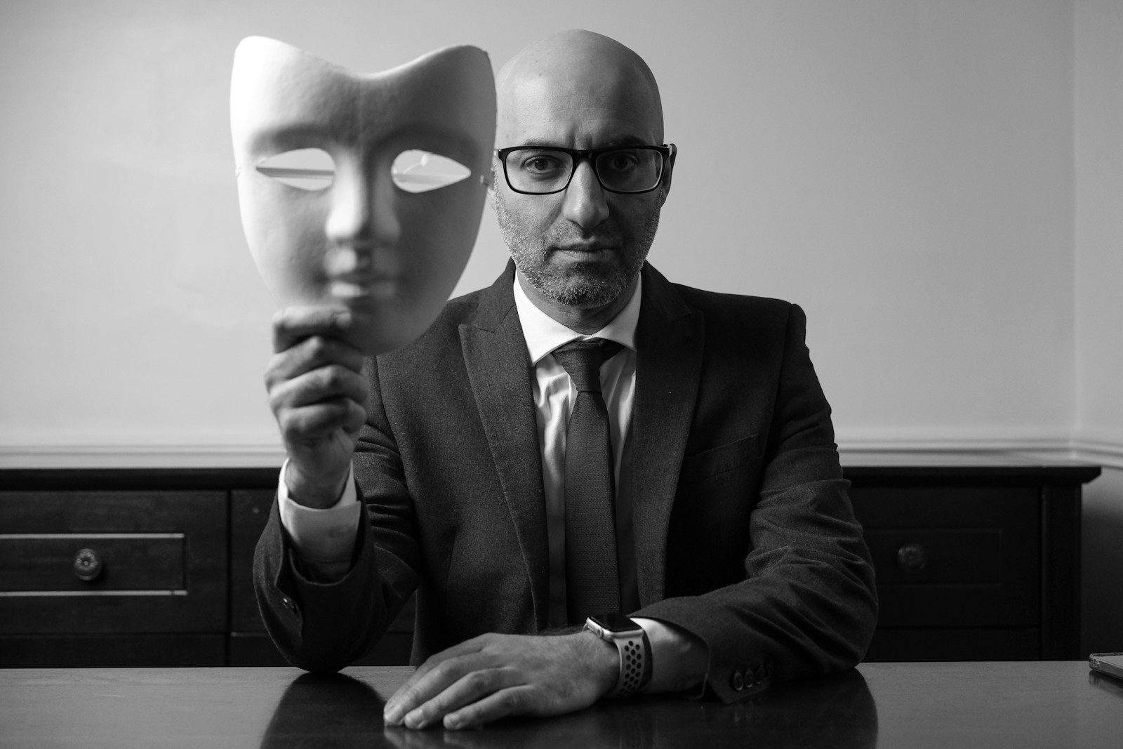 A man sitting at a table with a mask on his face